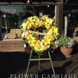 Yellow floral wreath on an easel with ribbon