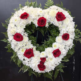 Heart-shaped floral wreath of white flowers with red roses