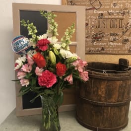 Mixed bouquet in a glass vase with a birthday balloon