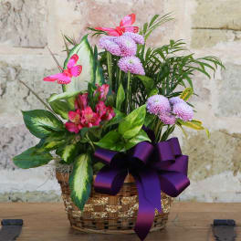 Basket arrangement with pink flowers, purple blooms, and butterflies