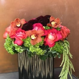 Pink roses and orchids in a black rectangular vase