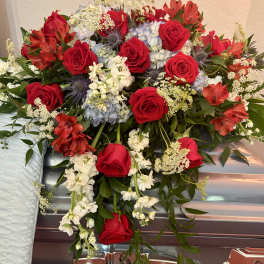 Red roses and red alstroemeria arranged on a silver casket