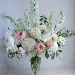 White and blush floral arrangement in a clear glass vase