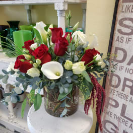 Red and white roses with calla lilies in a glass vase