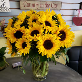 Bouquet of bright yellow sunflowers in a clear glass vase
