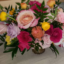 Mixed bouquet of pink, yellow, and white roses in a vase