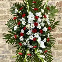 Standing floral spray with red and white flowers and palm fronds