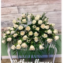Large white rose spray on a stand with ribbon