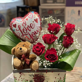 Red roses with a teddy bear and heart balloon in a decorative box