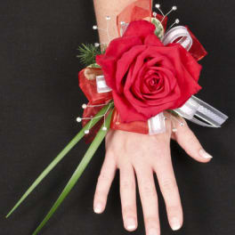 Red rose wrist corsage with ribbon and decorative accents