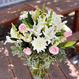 Pink roses and white lilies in a glass vase