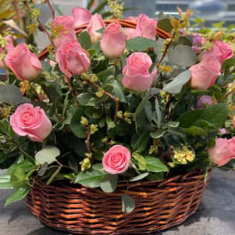 Pink roses arranged in a wicker basket.