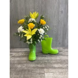 Yellow and white flowers arranged in bright green rain boots