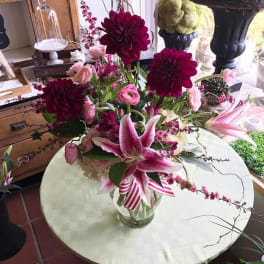 Pink lilies and dark magenta dahlias in a glass vase