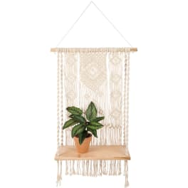 Potted plant on a hanging macrame shelf with a wooden board