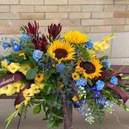 Bouquet with sunflowers, blue flowers, and yellow blooms tied with ribbons