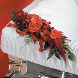 Red floral arrangement on a white casket