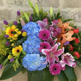 Colorful mixed bouquet with blue hydrangeas, pink lilies, and roses