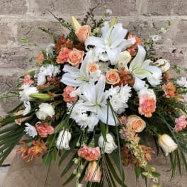 Large bouquet of white lilies, peach roses, and orange carnations