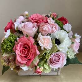 Pink and white rose arrangement in a wooden box
