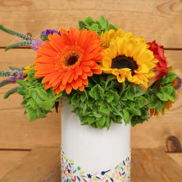 Bright gerbera daisies in a painted white vase