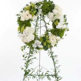 White and green floral wreath on a standing easel