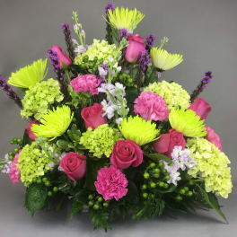 Bright pink roses and lime-green blooms in a mixed bouquet