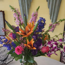 Colorful mixed flower arrangement in a clear glass vase