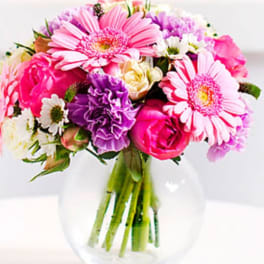 Pink and purple mixed bouquet in a clear glass vase
