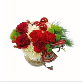 Red roses and carnations in a glass vase with ribbon and ornaments