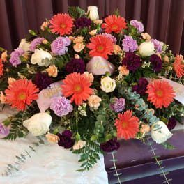 Large casket spray with gerbera daisies, roses, and carnations