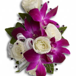 White roses and purple orchids arranged with ribbon accents