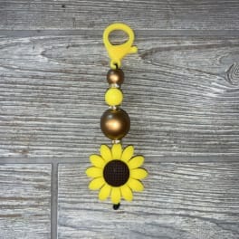 Yellow sunflower bead charm on a gray wood surface
