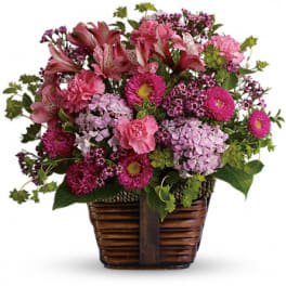 Pink and purple mixed flowers in a woven basket