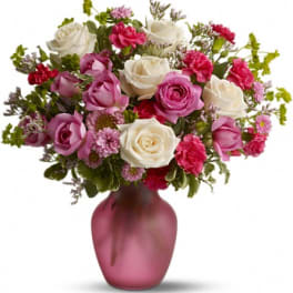 Pink and white roses with carnations in a pink vase