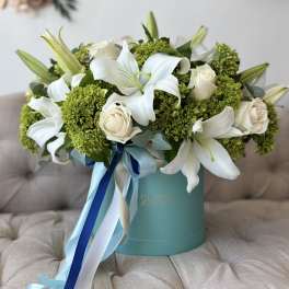 White lilies and cream roses in a turquoise hat box with blue ribbons
