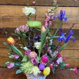 Colorful mixed flower arrangement in a white basket