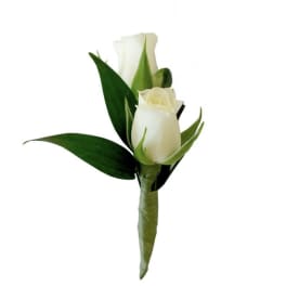 White rose boutonniere with dark green leaves