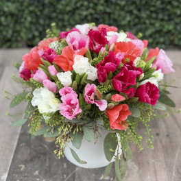 Colorful bouquet of carnations in a white vase