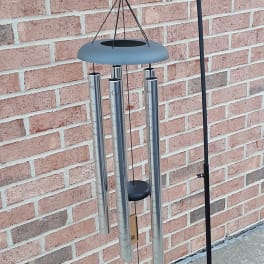Decorative wind chime with blue ribbon and green leaves