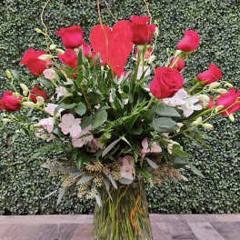 Pink roses and a red heart in a glass vase