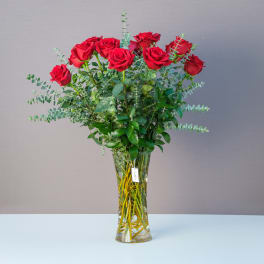Tall vase of red roses with eucalyptus greenery