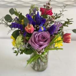 Mixed bouquet with a lavender rose in a glass vase