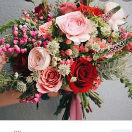 Hand-tied bouquet of pink and red roses with mixed small blooms