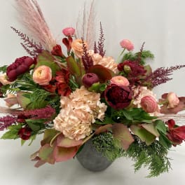 Mixed pink and burgundy floral arrangement in a gray vase