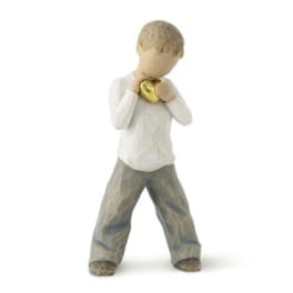 Small figurine holding a gold heart against its chest