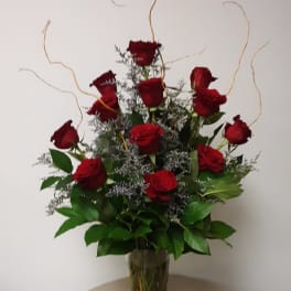 Tall bouquet of red roses in a clear glass vase