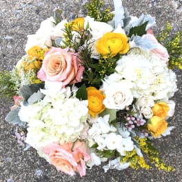 Bouquet of pink and yellow roses with white hydrangeas and mixed blooms