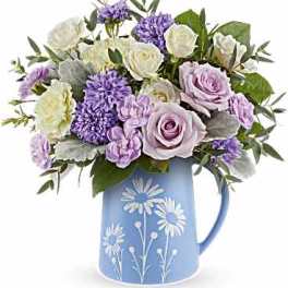 Lavender and white bouquet in a blue floral pitcher