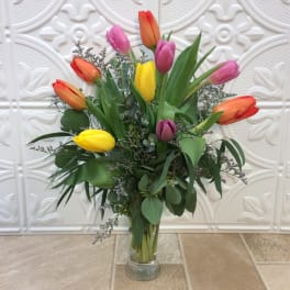 Bouquet of multicolored tulips in a clear glass vase